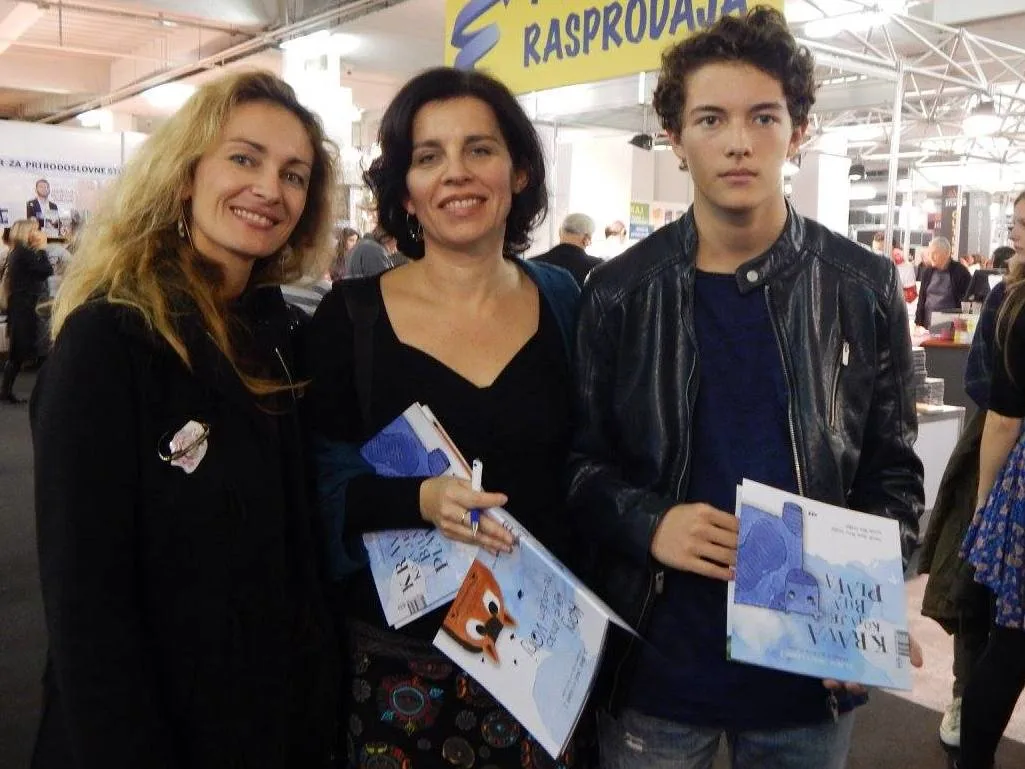 Interliber 2015., promocija slikovnice Krava koja je bila plava: troje posjetitelja drži slikovnice
