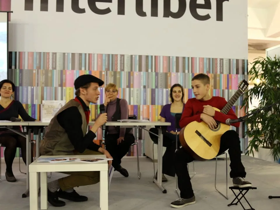Interliber 2016., promocija slikovnice Koka koja je sve gledala svisoka: dječak svira gitaru na pozornici